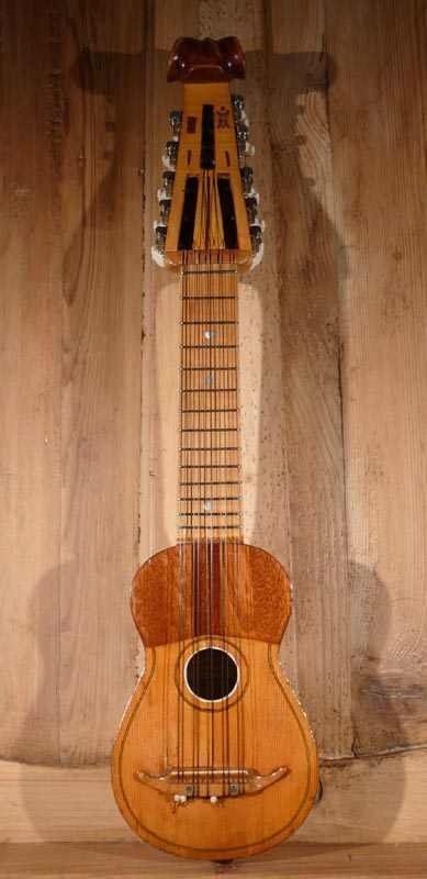 Traditional wooden charango displayed vertically on a rustic wood surface