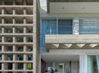 Modernist concrete house with brise-soleil screens and timber deck