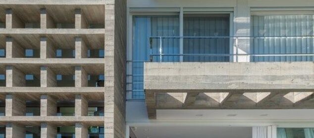 Modernist concrete house with brise-soleil screens and timber deck