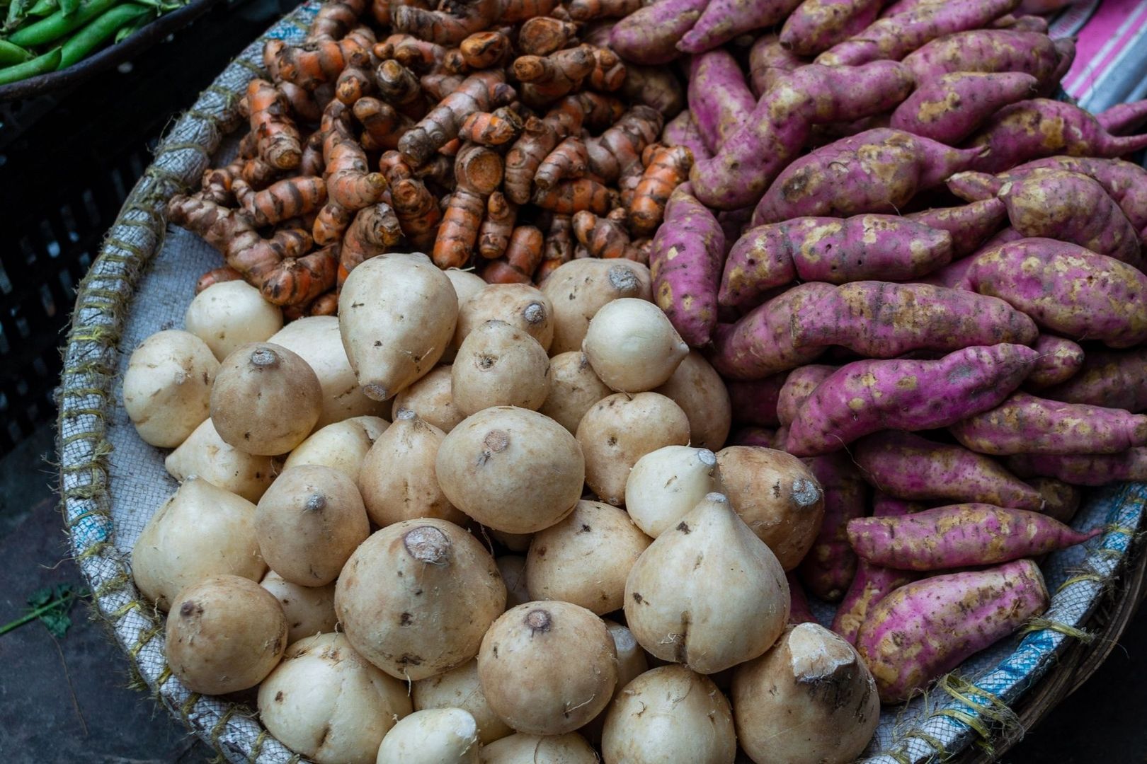 Fresh oca and other roots arranged at a market stall